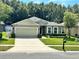 House exterior featuring a two-car garage and well-manicured lawn at 4813 Waters Gate Dr, Tavares, FL 32778
