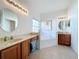 Spacious bathroom with a bathtub, double sinks, and wood cabinets at 5110 Chanticleer Dr, Leesburg, FL 34748