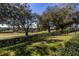 Picturesque backyard with a view of the golf course, mature trees, and a black metal fence at 5312 Meadow Hill Loop, Lady Lake, FL 32159