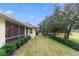 Landscaped backyard with screened porch and golf course view at 5312 Meadow Hill Loop, Lady Lake, FL 32159