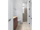 Hallway view of a bathroom with single vanity, wood cabinets, and glass enclosed tiled shower at 5312 Meadow Hill Loop, Lady Lake, FL 32159