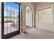 Arched entryway showcasing brick flooring and an exterior view with garden beds and a driveway at 5312 Meadow Hill Loop, Lady Lake, FL 32159