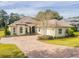 Tan house with a three-car garage and landscaped yard at 5312 Meadow Hill Loop, Lady Lake, FL 32159