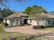Tan two-story house with a paved driveway and landscaping at 5312 Meadow Hill Loop, Lady Lake, FL 32159