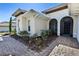 Home exterior with arched doorway and professional landscaping, complemented by a brick walkway at 5312 Meadow Hill Loop, Lady Lake, FL 32159
