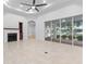 Bright living room with fireplace, tile floors, ceiling fan, and sliding doors to a patio at 5312 Meadow Hill Loop, Lady Lake, FL 32159