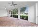 Large screened porch with paver floor and ceiling fan at 5312 Meadow Hill Loop, Lady Lake, FL 32159