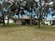 Home's rear view, showcasing a spacious lawn and lush landscaping at 5324 Treasure View Way, Leesburg, FL 34748