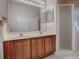 Clean bathroom with double vanity, large mirror, and walk-in shower at 5812 Ansley Way, Mount Dora, FL 32757