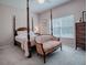 Elegant bedroom with four-poster bed, sitting area, and plenty of natural light at 5812 Ansley Way, Mount Dora, FL 32757