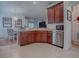 Open-concept kitchen with stainless steel appliances, tile flooring, and wooden cabinetry at 5812 Ansley Way, Mount Dora, FL 32757