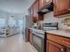 Modern kitchen features stainless steel appliances, wooden cabinets, and a breakfast bar at 5812 Ansley Way, Mount Dora, FL 32757