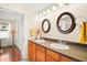 Bathroom with double vanity, dark countertop and circular mirrors at 7206 Earlwood Ave, Mount Dora, FL 32757