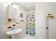 Small bathroom with pedestal sink, shower, and colorful accents at 7206 Earlwood Ave, Mount Dora, FL 32757