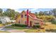 Charming yellow house with red trim, landscaped yard, and paved driveway at 7206 Earlwood Ave, Mount Dora, FL 32757
