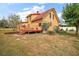 Yellow house with red trim, deck and landscaping at 7206 Earlwood Ave, Mount Dora, FL 32757