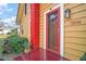 Red front door with screen door and porch at 7206 Earlwood Ave, Mount Dora, FL 32757