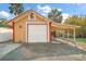 Detached garage with white door and covered carport at 7206 Earlwood Ave, Mount Dora, FL 32757