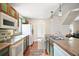 Kitchen with teal cabinets, white appliances, and double sink at 7206 Earlwood Ave, Mount Dora, FL 32757
