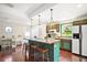 Kitchen with teal cabinets, island, and hardwood floors at 7206 Earlwood Ave, Mount Dora, FL 32757