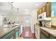Kitchen with teal cabinets, island, and hardwood floors at 7206 Earlwood Ave, Mount Dora, FL 32757