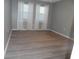 Bright bedroom with modern flooring, neutral paint and two windows at 723 Perkins St # 104, Leesburg, FL 34748