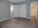 Bright bedroom featuring wood-look floors, neutral walls, and a closet with bi-fold doors at 723 Perkins St # 104, Leesburg, FL 34748