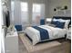 Comfortable bedroom with a plush bed, natural light, and stylish blue and white decor at 723 Perkins St # 104, Leesburg, FL 34748
