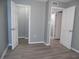 Neutral bedroom featuring wood-look floors and open doors to closets and hallways at 723 Perkins St # 104, Leesburg, FL 34748