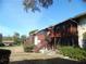 Exterior shot of complex featuring second-story screened porches with wooden railings and stairways at 723 Perkins St # 104, Leesburg, FL 34748