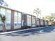 Brick condo building with palm trees and parking at 723 Perkins St # 104, Leesburg, FL 34748