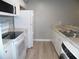 Modern kitchen featuring white appliances, granite counters and wood-look flooring at 723 Perkins St # 104, Leesburg, FL 34748