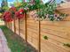 Stylish wooden fence adorned with vibrant pink and red flowering vines enhancing the property's curb appeal at 805 Hackett Ct, Mount Dora, FL 32757