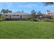 Well-maintained backyard with lush green lawn, mature landscaping, and a screened lanai at 1029 Juliette Blvd, Mount Dora, FL 32757