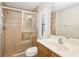 Bathroom featuring a sliding glass shower, shuttered window, and vanity with a granite countertop at 1029 Juliette Blvd, Mount Dora, FL 32757