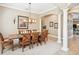 Formal dining room with elegant columns, an ornate chandelier, and wood furnishings at 1029 Juliette Blvd, Mount Dora, FL 32757