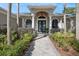 Stunning front entrance with a double door entry, lush greenery, and a brick walkway at 1029 Juliette Blvd, Mount Dora, FL 32757