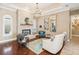 Cozy living room featuring a stone fireplace, hardwood floors, and elegant furnishings at 1029 Juliette Blvd, Mount Dora, FL 32757