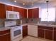 Kitchen features wood cabinets and white appliances at 10337 Se 176Th St, Summerfield, FL 34491