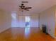 Bright living room with wood floors, ceiling fan, and sliding glass doors at 10337 Se 176Th St, Summerfield, FL 34491