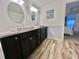 Double vanity bathroom with modern dark cabinets and round mirrors at 105 Royal Palm Dr, Leesburg, FL 34748