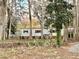 White single-wide mobile home nestled among trees at 105 Royal Palm Dr, Leesburg, FL 34748