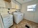 Laundry room with washer, dryer, and storage cabinets at 105 Royal Palm Dr, Leesburg, FL 34748