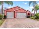 Brick driveway and three-car garage with screened doors at 1130 Meadowbend Dr, Leesburg, FL 34748