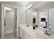 Bathroom with double vanity and view into bedroom at 11644 Osprey Pointe Blvd, Clermont, FL 34711