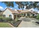 Two-story house with tile roof, three-car garage, and manicured landscaping at 11644 Osprey Pointe Blvd, Clermont, FL 34711