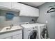 Laundry room with washer, dryer, and upper cabinets at 11644 Osprey Pointe Blvd, Clermont, FL 34711