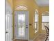 Bright foyer featuring a decorative glass door and elegant transom window, complemented by neutral walls at 12163 Se 176Th Loop, Summerfield, FL 34491