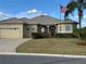 Well-maintained single-story home with a two-car garage, lush lawn, and inviting front entrance at 12163 Se 176Th Loop, Summerfield, FL 34491