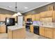 Well-lit kitchen featuring a center island, stainless steel appliances, and light wooden cabinetry at 12163 Se 176Th Loop, Summerfield, FL 34491